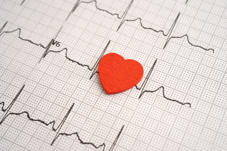 Graphique ECG avec un cœur rouge illustrant la formation avancée en cohérence cardiaque.