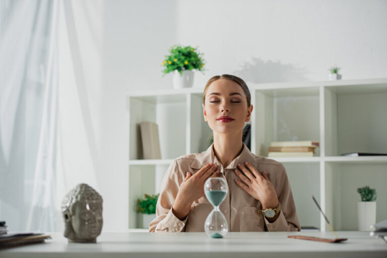 Femme au bureau pratiquant un exercice de respiration pour la gestion du stress et des agressivités.