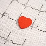Graphique ECG avec un cœur rouge illustrant la formation avancée en cohérence cardiaque.