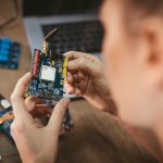 Gros plan sur une carte STM32 tenue en main lors d’une formation en programmation embarquée.