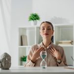 Femme au bureau pratiquant un exercice de respiration pour la gestion du stress et des agressivités.
